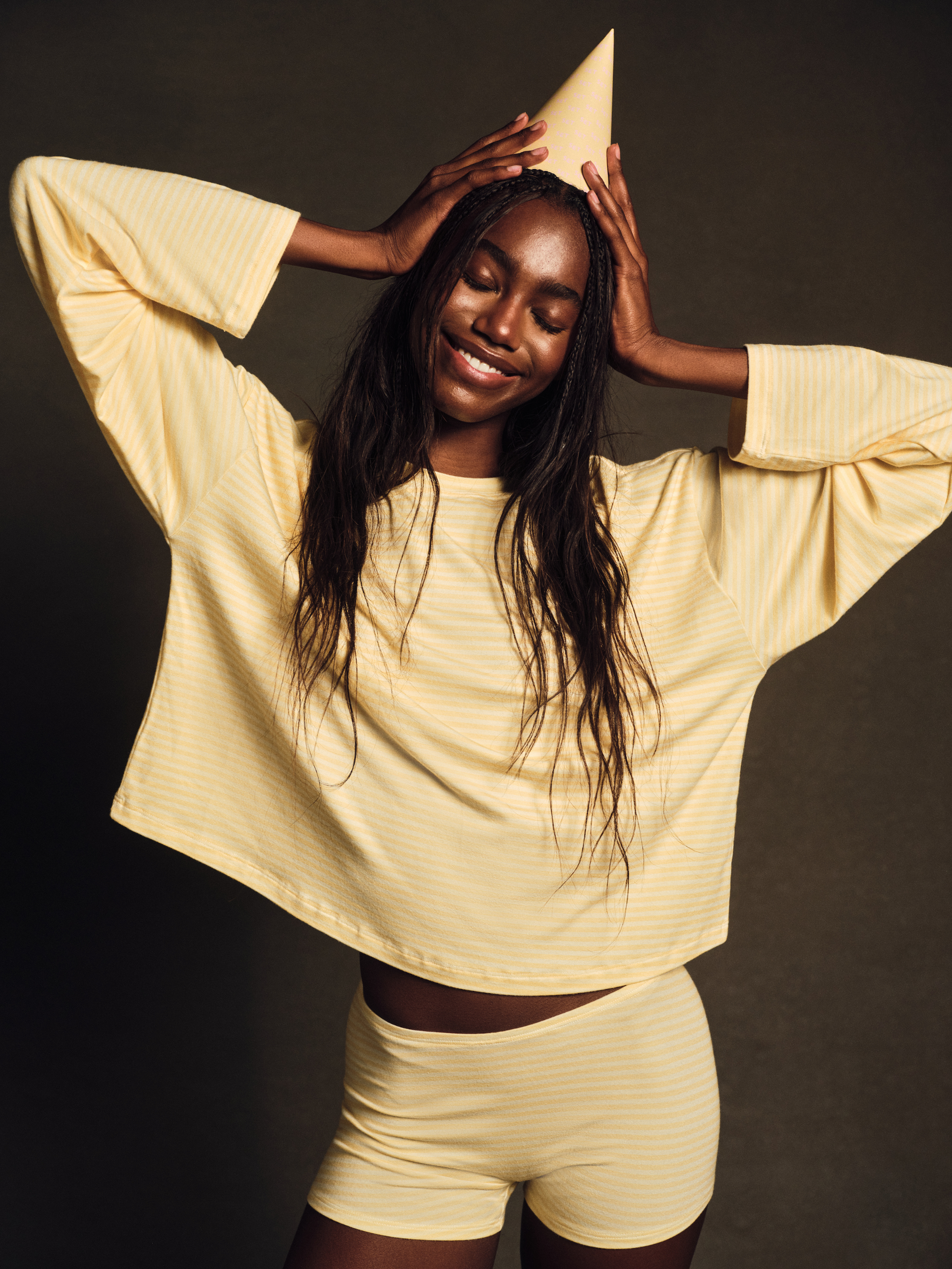 Woman wearing a yellow striped outfit against a dark background <model-info>Nina D wears a size S and is 5’10”, 24” waist, 31½" bust.</model-info>