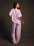 Person wearing a matching lavender outfit against a dark background