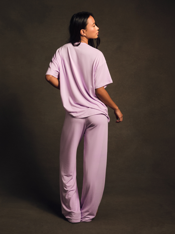 Person wearing a matching lavender outfit against a dark background