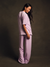 Woman wearing a matching lavender top and pants set against a dark background