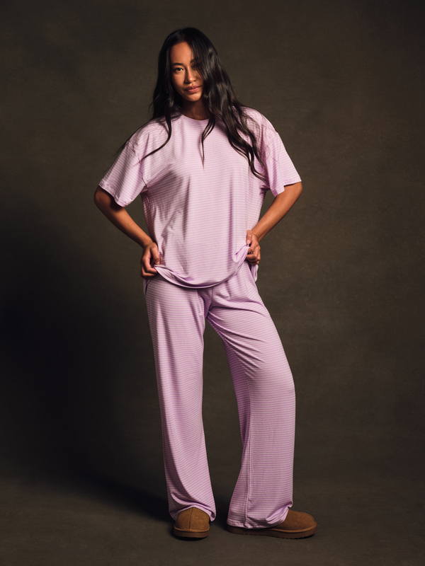 Person wearing a light purple outfit on a dark background 