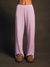 Person wearing light purple striped pajama pants on a dark background