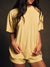 Woman wearing a yellow polka dot outfit against a dark background <model-info>Amber wears a size S and is 5’½”, 22½” waist, 30B" bust.</model-info>