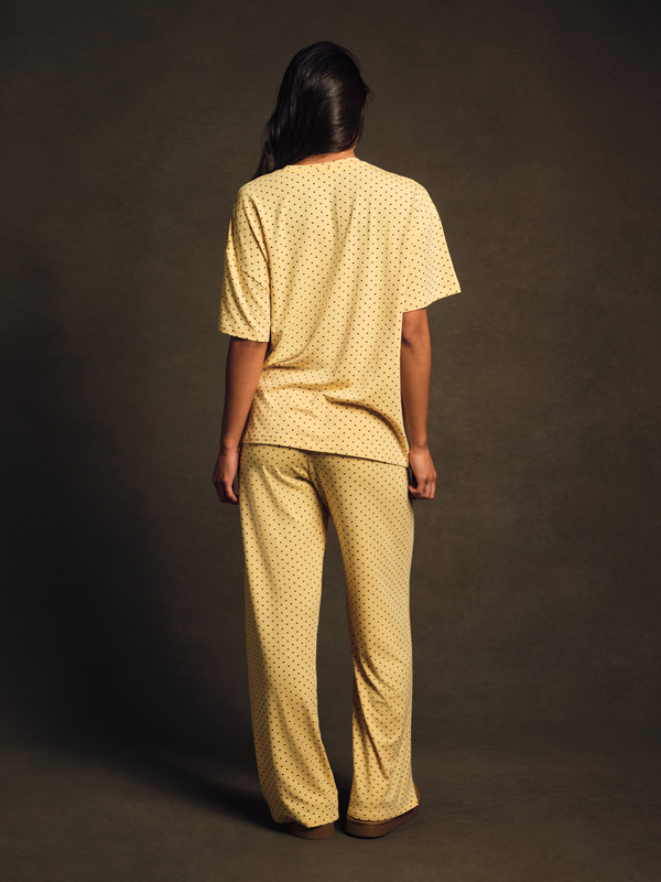 Person wearing a yellow patterned outfit against a dark background