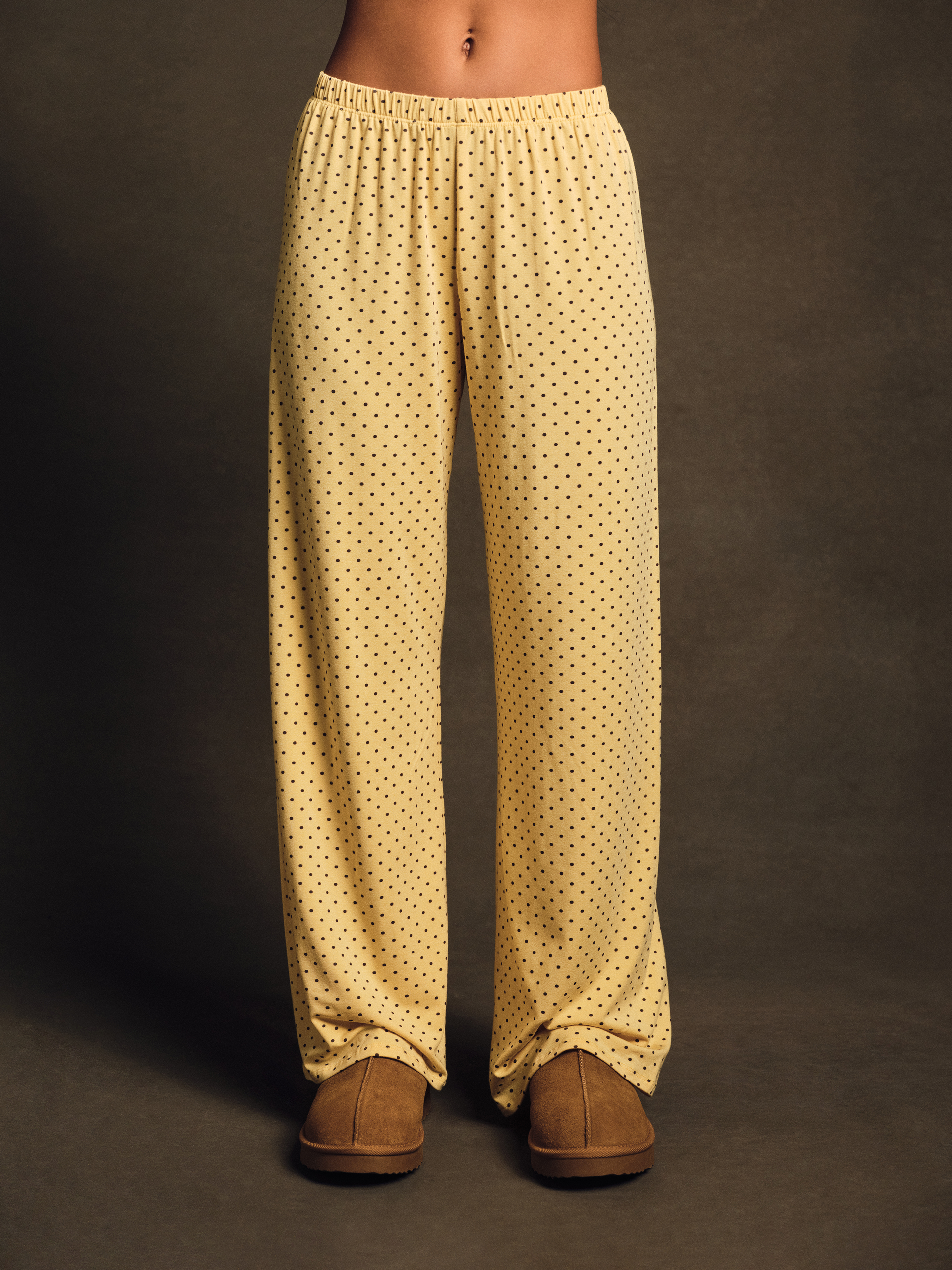 Yellow patterned pants worn by a person on a dark background