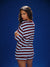Woman wearing a striped pajama set against a blue background