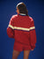 Person wearing a red tracksuit with white and blue stripes on a blue background
