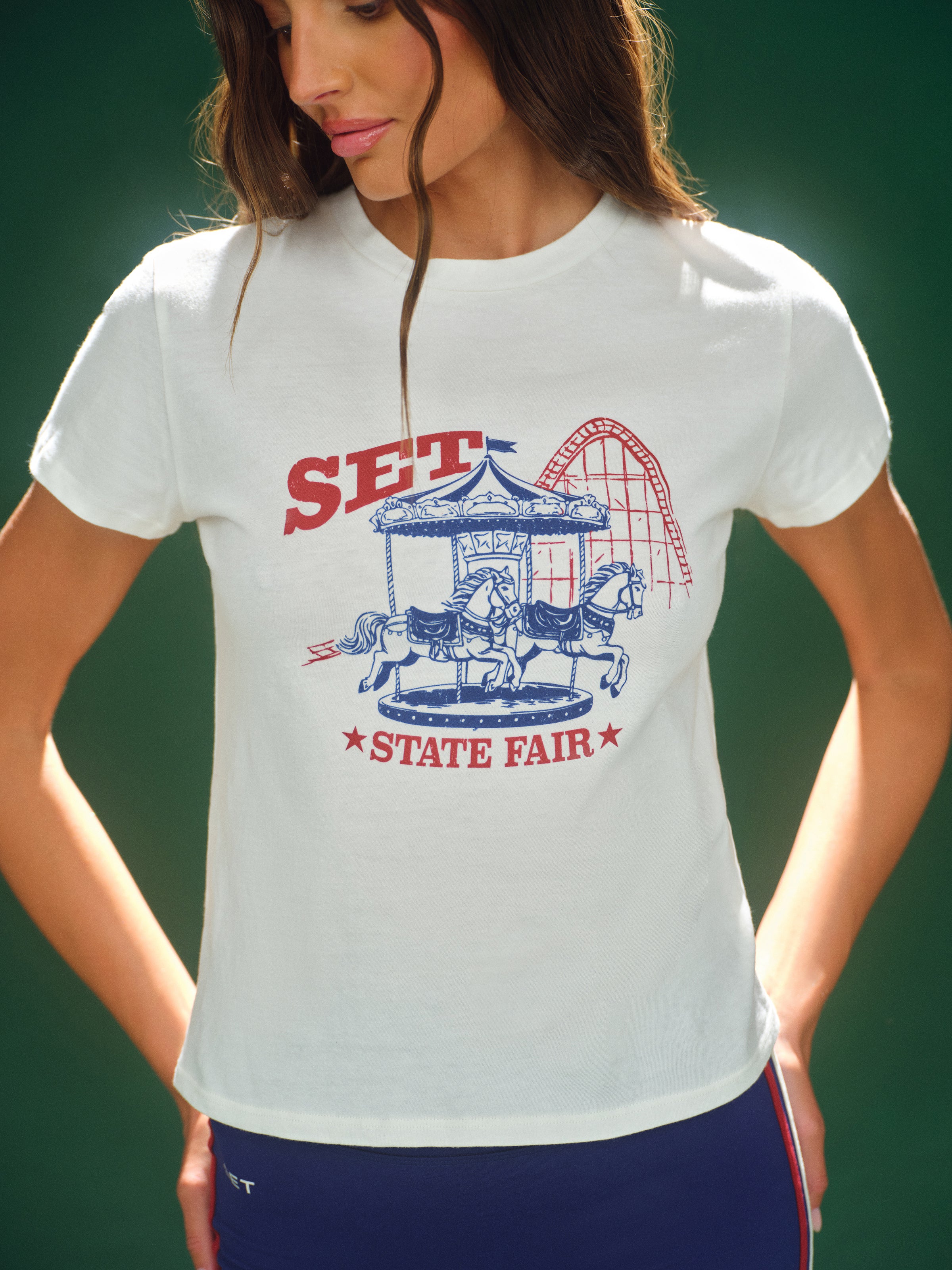 Woman wearing a white t-shirt with a State Fair graphic design. 