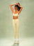 A woman modeling a matching pale yellow and black polka dot activewear set, consisting of a sports bra and high-waisted leggings, paired with white socks and sneakers, against a textured sage green studio backdrop. <model-info>Meeya wears a size XS and is 5’7, 23” waist, 32B bust.</model-info> 