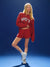 Person wearing a red 'SET' sweatshirt and shorts on a blue background