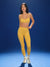 Woman wearing a yellow sports bra and leggings set on a blue background <model-info>Jasmine wears a size S and is 5'8, 25” waist, 32C bust.</model-info>