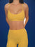 Person wearing a yellow sports bra and leggings with 'SET' branding on a blue background