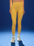 Person wearing yellow leggings on a blue background
