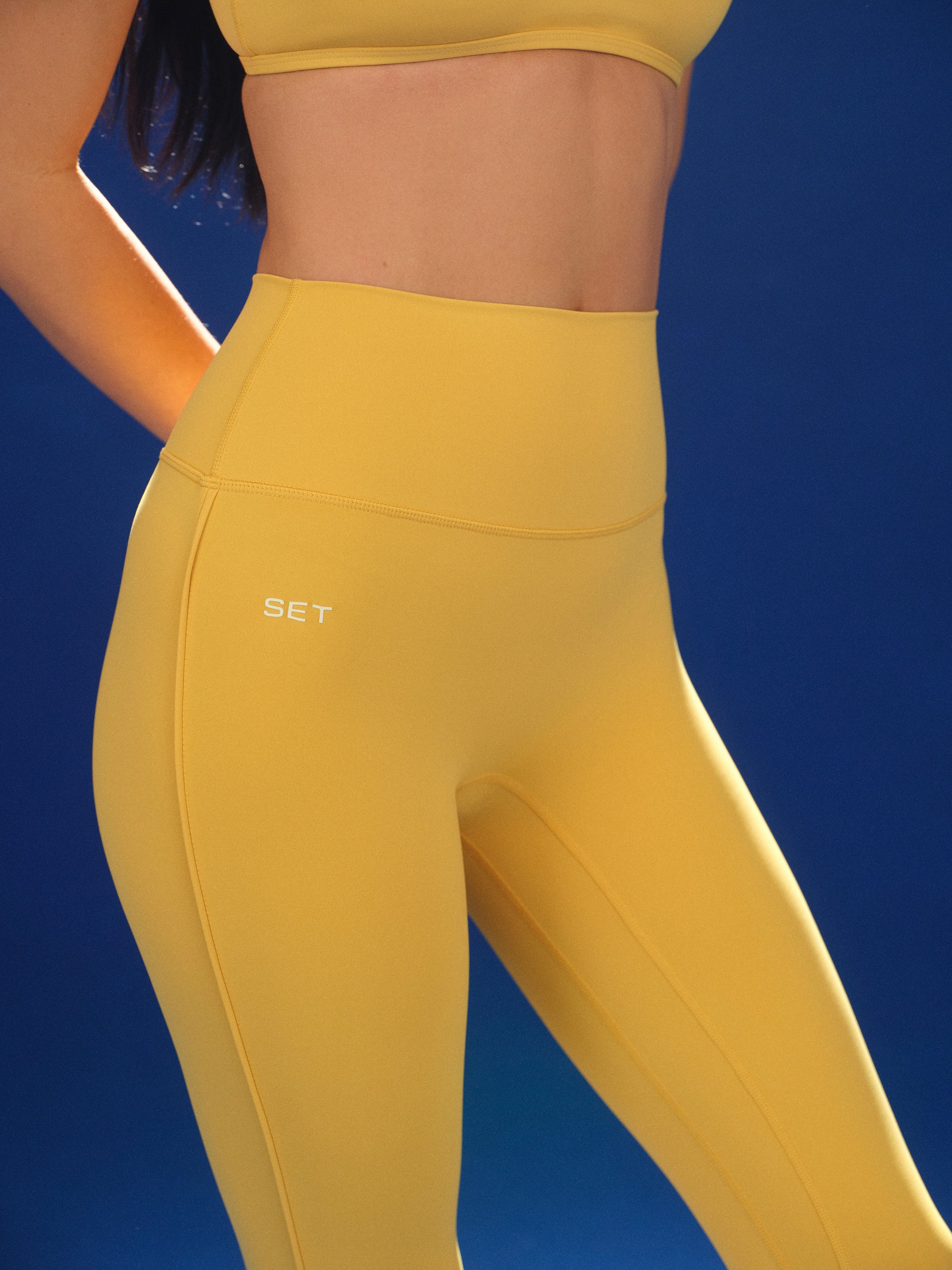 Yellow leggings with 'SET' branding on a blue background
