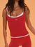 Red tank top and leggings with white accents on a model against an orange background