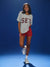 Woman wearing a gray 'SET' t-shirt and red shorts on a blue background