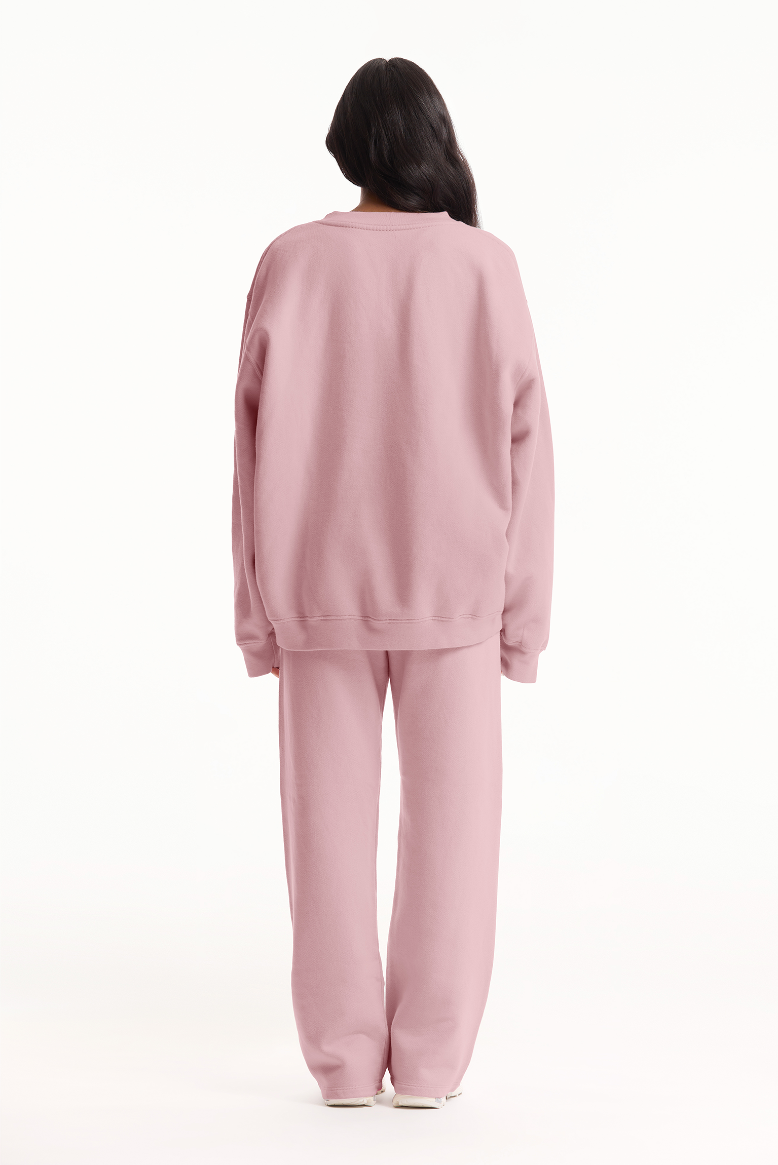 Person wearing a pink pajama set on a white background