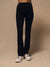 Black high-waisted athletic leggings worn by a model, paired with white trail running shoes, against a solid beige studio background.