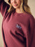 A close up of a model wearing a sweatshirt with a small embroidered 'SET' graphic on the left chest.