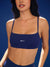 Woman wearing a blue sports bra with 'SET' branding against a blue background