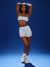 Woman in athletic wear posing against a blue background