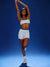 Woman in athletic wear posing against a blue background