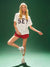 Woman wearing a white t-shirt with 'SET' and red shorts on a green background