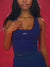 Woman wearing a blue sports bra with 'SET' logo against a red background