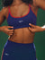 Person wearing a blue sports bra and leggings with 'SET' branding on a green background