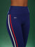 Navy blue leggings with red and white stripes on a green background