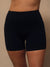 Black high-waisted athletic biker shorts worn by a model, shown from the waist to mid-thigh against a plain beige studio background. <model-info>Irene wears a size M and is 5’8”, 30” waist, 36" bust.</model-info>
