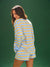 Woman wearing a blue and yellow striped outfit against a green background