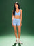 Woman wearing a blue athletic outfit on a green background