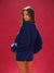 Woman wearing a blue tracksuit against a red background