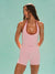 Woman wearing a pink athletic outfit against a light blue background <model-info>Logan wears a size XS and is 5’9½”, 24” waist, 32B bust.</model-info>