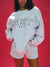 Person wearing a light blue sweatshirt with 'SET' text on a red background