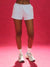 Person wearing white shorts and sneakers on a pink background