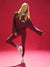 Woman in burgundy sweater and leggings posing against a red background