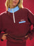Person wearing a burgundy sweatshirt with a visible brand logo against a red background