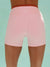 Pink athletic shorts worn by a person on a light blue background <model-info>Logan wears a size XS and is 5’9½”, 24” waist, 32B bust.</model-info>