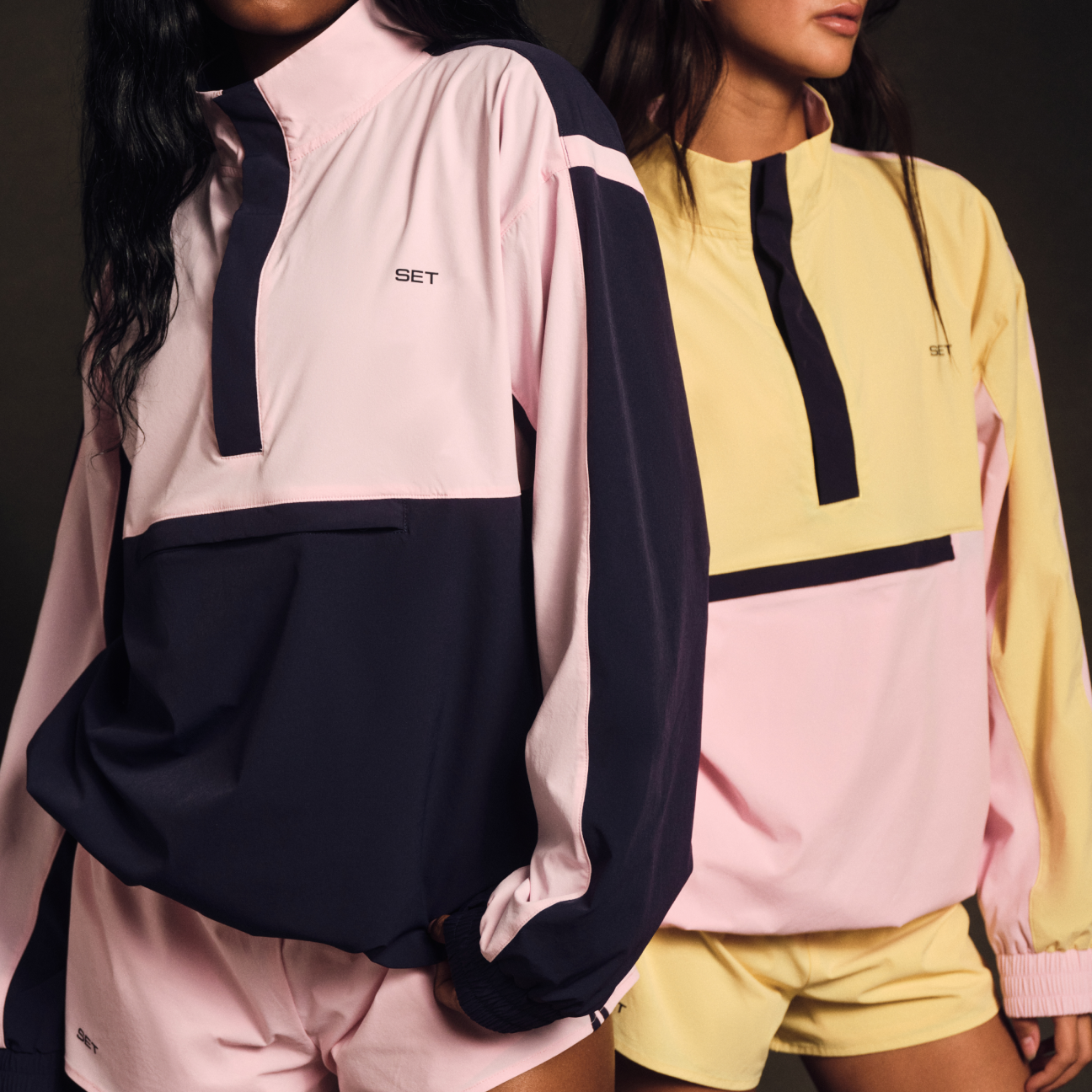 Two people wearing colorful athletic jackets with a visible brand logo.