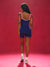 Person wearing a blue and red jumpsuit against a red background