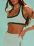 Woman wearing a green and white sports bra with 'SET' branding against a light blue background