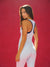 Woman wearing a white and blue jumpsuit against a red background