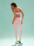 Woman wearing a pink athletic outfit on a light green background
