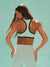 Woman wearing a green and white sports bra against a light blue background