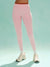 Person wearing pink leggings and white sneakers on a light blue background
