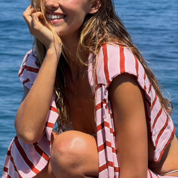 Woman wearing a striped set by the water.