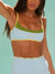 Woman wearing a sports bra with a visible brand logo against a light green background <model-info>Logan wears a size XS and is 5’9½”, 24” waist, 32B bust.</model-info>