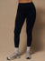 A person wearing black high-waisted leggings, white socks, and gray running shoes, standing against a plain beige studio background.